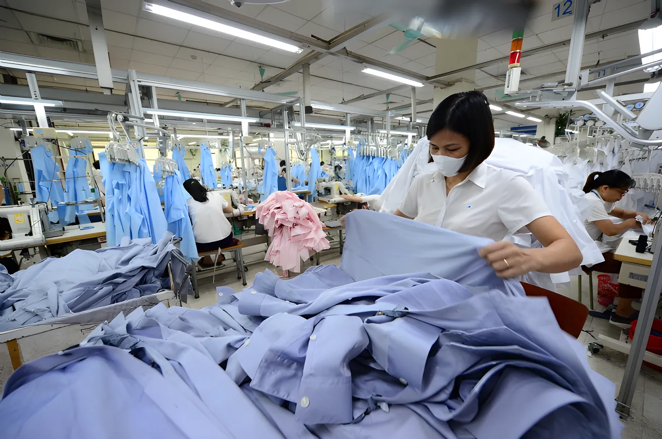 Pekerja di pabrik maklon sedang memeriksa kualitas kemeja yang diproduksi.