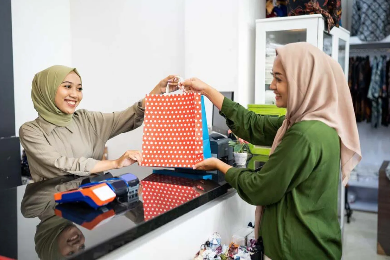 Seorang wanita memberikan layanan pelanggan yang ramah.