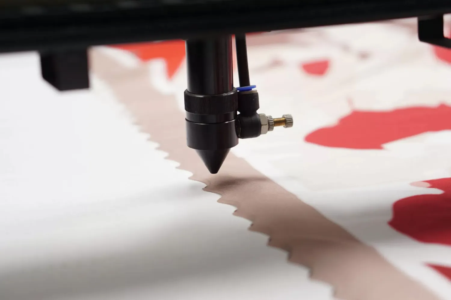 Mesin laser cutting kain memotong dengan kecepatan tinggi.