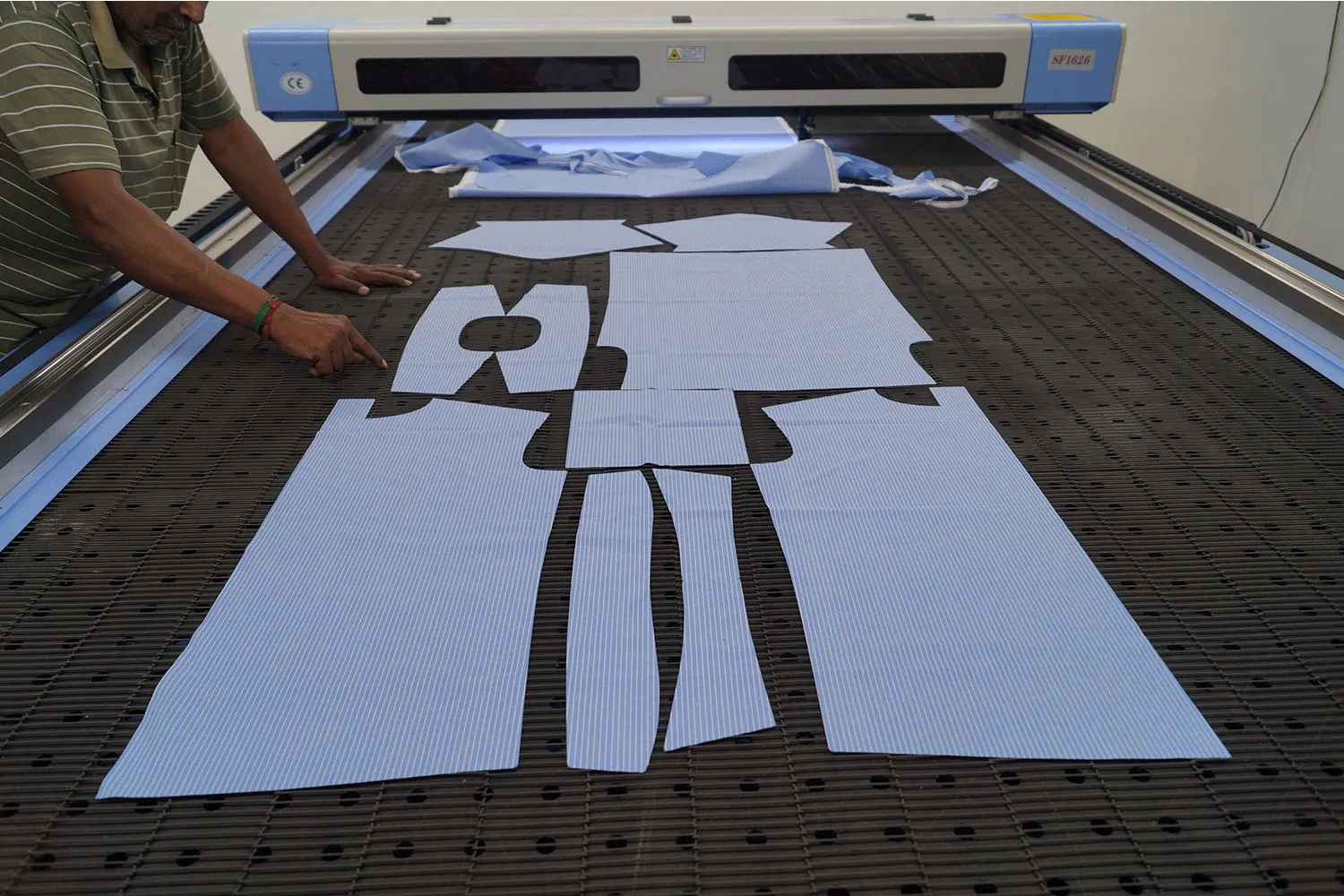 Mesin laser cutting memotong kain dengan presisi tinggi.