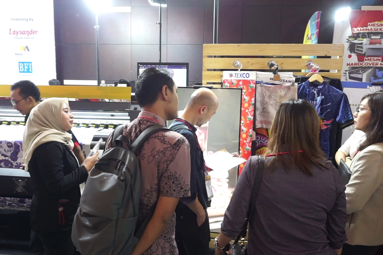 Booth Laysander penuh dengan pengunjung di Surabaya Printing Expo 2024, menampilkan mesin cetak terbaru.