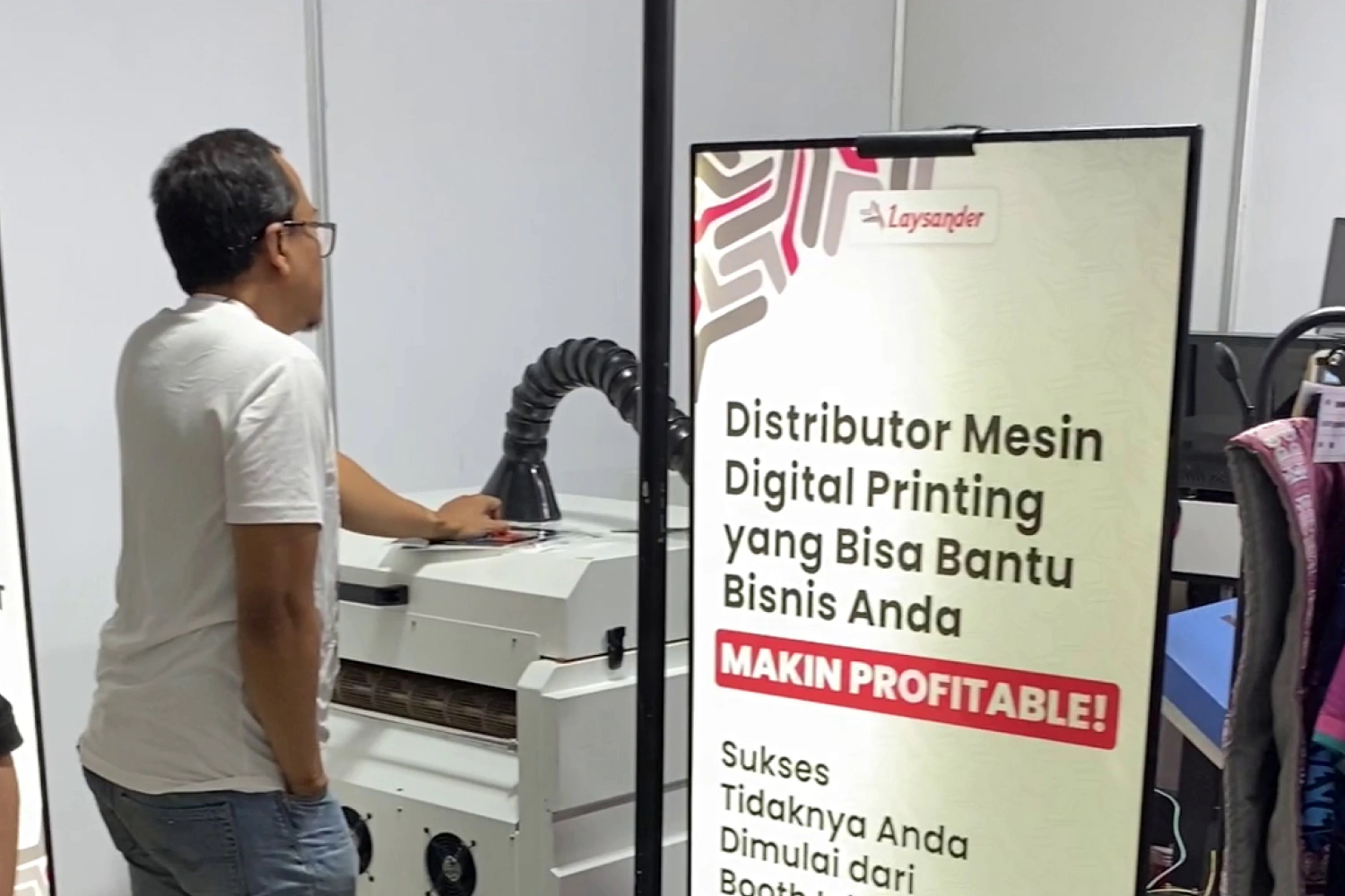 Pengunjung melihat mesin printing di booth Laysander selama IAPE 2024.